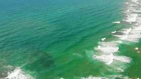 Aerial view on waves near sand beach. Drone flying above turquoise mediterranean sea, Lazio, Italy.