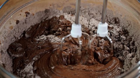 Mixing chocolate cake batter with mixer.