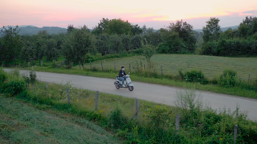 Man slowly rides a motorbike through the village | Shutterstock HD Video #1014360518