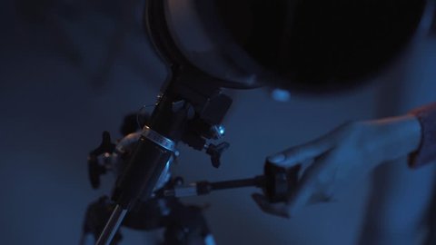 Young smart woman stargazing with her professional telescope close up, astronomy and science concept