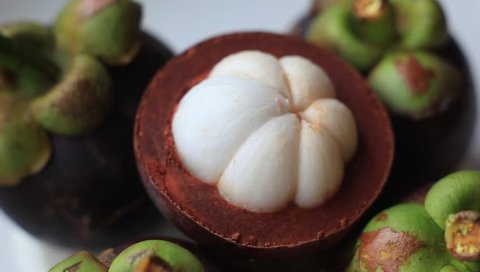 Close up the fresh thai purple mangosteen with rotating 360 degrees.