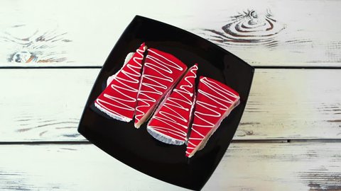Slices of red cakes on black plate. Four pieces of cheesecake with red jelly, top view. Beautiful taste and design.