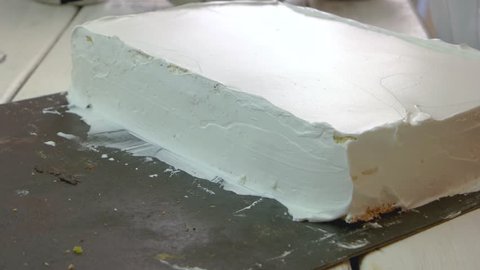 Baker smoothing cake with whipped cream icing. Confectioner working with creamy cake. Cooking yummy dessert for holiday.