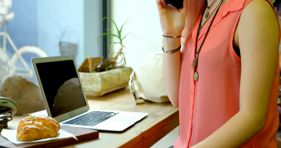 Beautiful young woman talking on the mobile phone in cafe 4k