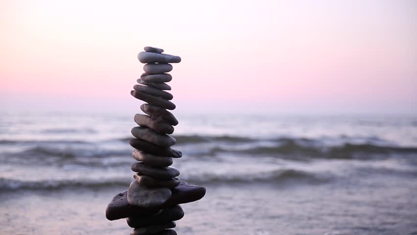Stone tower on the sea coast on a sunset. Balance and patience  | Shutterstock HD Video #1014401714