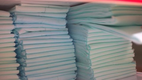 Nurse hand takes a few nappies out of the pile. Partnerships with businesses and organizations, healthcare manufacturers providing contributions in the form of needed resources and services. Covid-19 