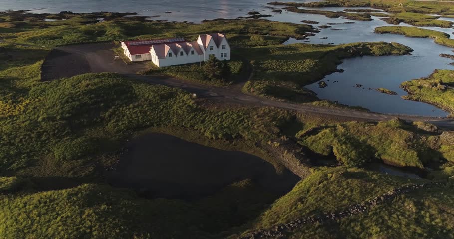 Aerial: House on the Atlantic ocean coast Mossy lava field Small pond Dramatic lightening