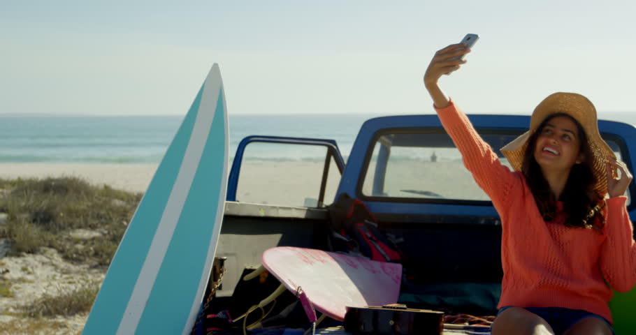 Couple taking selfie with mobile phone near car on the beach 4k