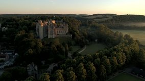 Drone tracks around Arundel Castle and town in the light of a misty summer dawn. Shot from Public Land