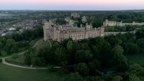 Drone tracks slowly around Arundel Castle and town in the twilight before dawn. Shot from Public Land
