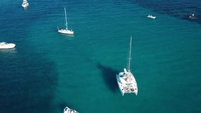 View from above, aerial view of a catamaran and some boat on a transparent and turquoise sea. Emerald Coast, Sardinia, Italy.