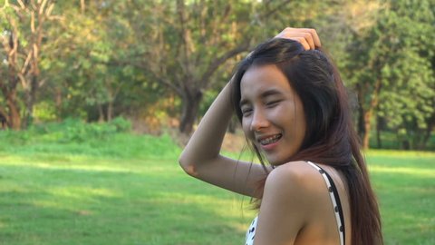 Slow motion portrait of joyful Asian woman , happy natural look in the park.