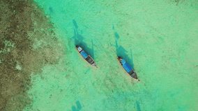 Aerial video above two longtail boats on Laem Tong, Part Of Phi Phi Island.