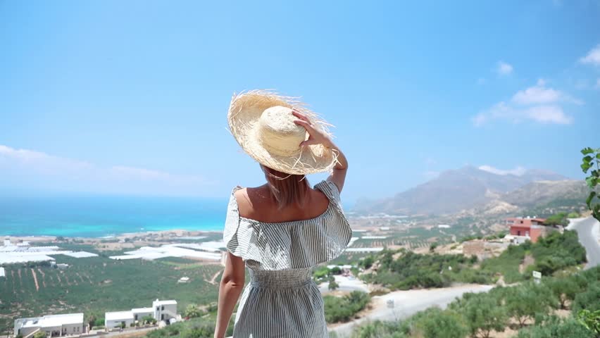 young woman looking at tropical resort seascape, back view
