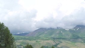Panoramic video, green mountains are covered by clouds. Hilly landscape