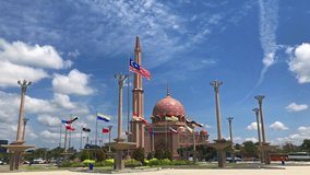 Wide angle view video of flags in Malaysia waving with blue sky in the background in Putrajaya, Malaysia.