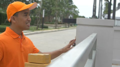 Delivery man ring a bell to call customers for receive a parcel at front home