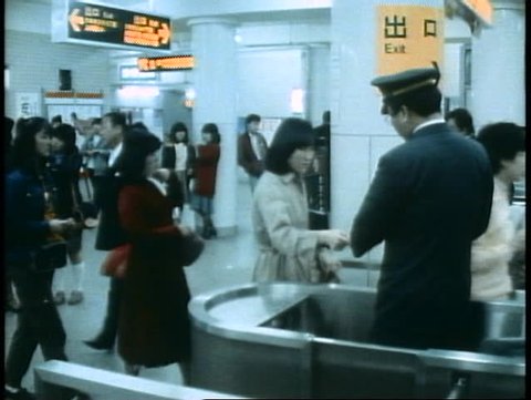TOKYO, JAPAN, 1982, The Tokyo Subway, people passing through turnstiles