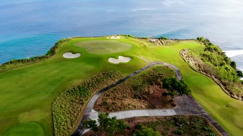 Aerial view of luxury golf field next the cliff, ocean and beach in Bali island, Indonesia.
 Aerial view of footpath on golf course.