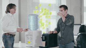 Two male colleagues talk about work and drink water from a water cooler on a hot summer day at the office. The concept of heat and office everyday life - Powered by Shutterstock - Get 15% off with code: PIKWIZARD15