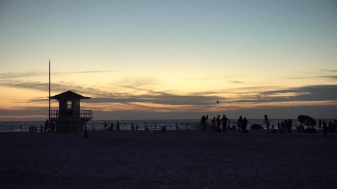 Clearwater, United States - June, 2017: Contre jour of people relaxing on a beach at sunset
