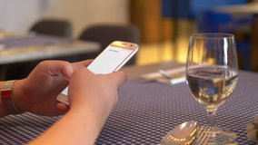 Professional video of woman using mobile phone in the restaurant in 4k slow motion 60fps
