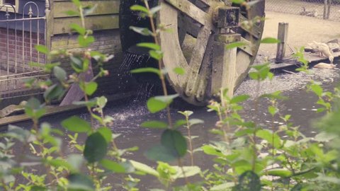 Slow motion dolly and tilt-up of water wheel and old house in Enkhuizen, Netherlands. Filmed at 240fps.