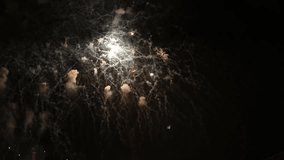 Great universe shapes projected by fireworks on the night sky, in slow motion video. Colorful rain showers of fireworks on the dark night background. Festive event accompanied by holiday salves.