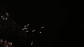 Floral composition of fireworks on the night sky, in slow motion video. Colorful rain showers of fireworks on the dark night background. Festive event accompanied by holiday salves. Holiday relax time