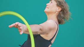 Handsome 60 years old women are smiling. She twists a Hula Hoop on her hand with great enthusiasm. Fitness process. - Powered by Shutterstock - Get 15% off with code: PIKWIZARD15