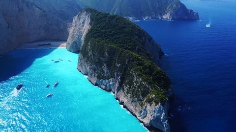 Aerial drone video of iconic "Navagio" or Shipwreck beach, one of the most beautiful beaches in the world with deep turquoise clear sea, Zakynthos island, Ionian, Greece