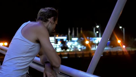 Adult man thinking about life and standing on the bridge at night city