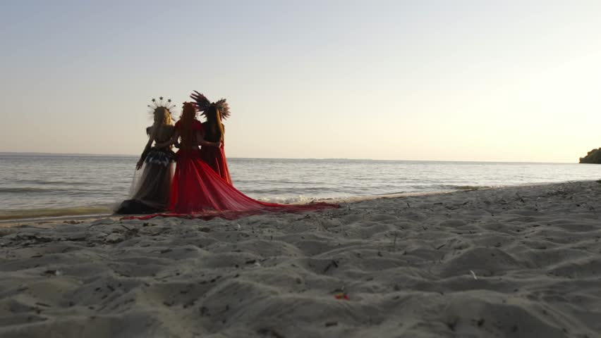 A lot of women in cosplay dress stand at seashore
