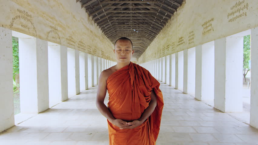 Authentic real monk walking in ancient passage way of temple Bagan Myanmar / Burma Note: Writing on walls are messages of donations from local villages.  Slow motion hand held.