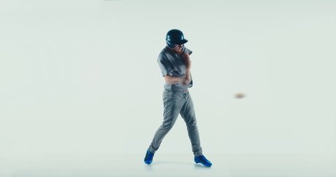 Caucasian professional baseball player batter wearing generic uniform hitting a ball isolated on white background. 4K UHD 60 FPS SLOW MOTION