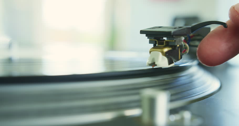 Closeup of hand placing the stylus needle on record. Lockdown shot of vinyl record on turntable. Man playing songs on vintage record player at home. 4K Resolution. | Shutterstock HD Video #1014548666