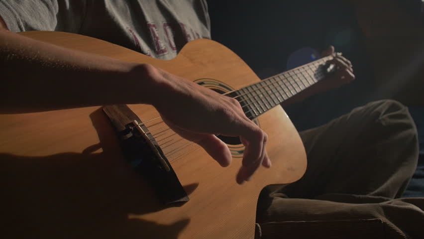 Man Plays An Acoustic Guitar In Dark Room
