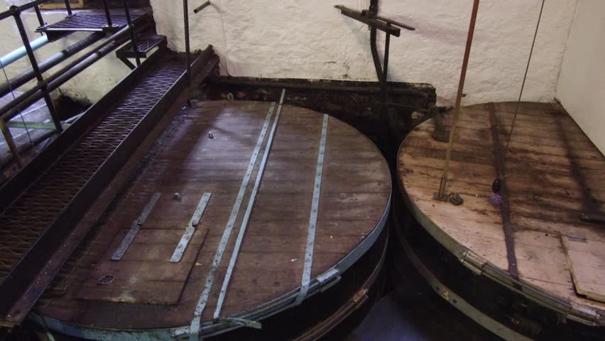 Low wines tubs and open spirit safe at whiskey distillery in Scotland