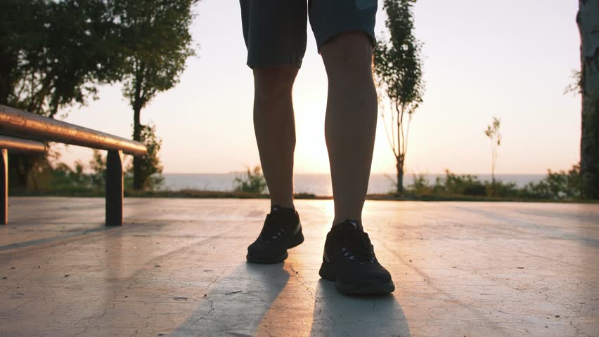 Fit handsome middle aged man walking on sports ground with sea background, close up shot