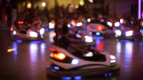 Defocused view of bumper car attraction nighttime view of funny atmosphere at the amusement park 4K UHD cinematic camera used