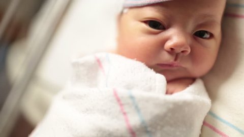 Close Up Portrait of Newborn Baby in Hospital Bed