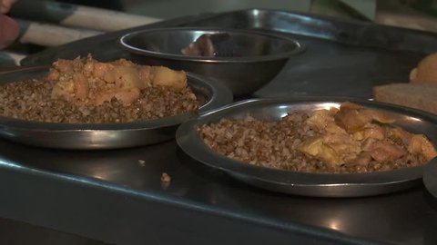 Buckwheat porridge with meat sauce in a soldier's canteen, the military takes plates with food