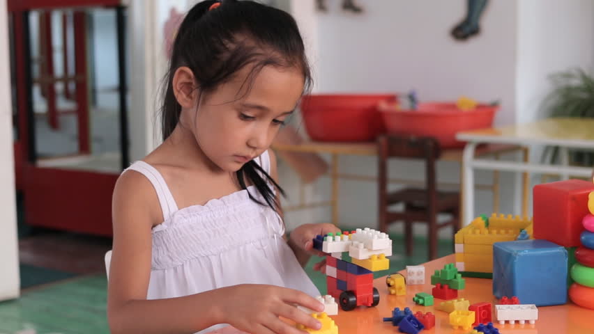 Little girl playing with colorful bricks