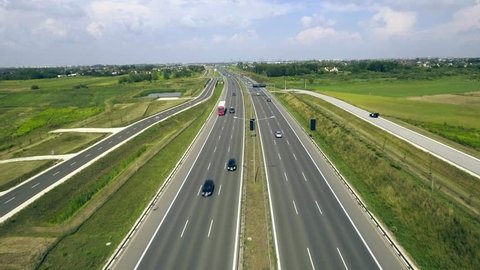 4K. Aerial view on the highway with cars. Highway is filled with cars, trucks and cars leave the city. Highway with dense traffic - tracking shot, natural lighting
