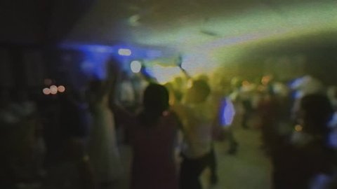 Old VHS cassette tape film of great wedding party with silhouettes of people dancing on the dancefloor disco and traditional dance