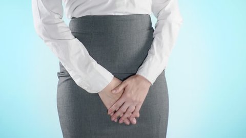 sick business woman with hands holding pressing her crotch lower abdomen. Medical or gynecological problems, healthcare concept. 4k, close-up, color background. Slow motion