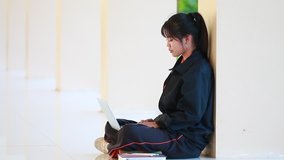 Student learning online study concept: Beautiful Asian girl learning and writing in notebook or homework, sitting short notes, use computer laptop at school for learn of e-learning
