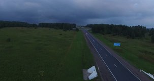4K aerial video of green fields and highway on dark summer evening near huge Plesheevo Lake in outskirts of historical town of Pereslavl-Zalessky in Yaroslavskaya oblast north-east of Moscow, Russia