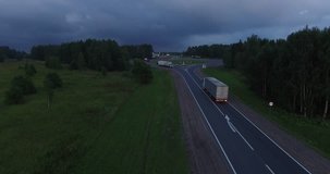 4K aerial video of green fields and highway on dark summer evening near huge Plesheevo Lake in outskirts of historical town of Pereslavl-Zalessky in Yaroslavskaya oblast north-east of Moscow, Russia