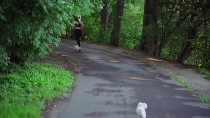 Girl runs through park in the morning